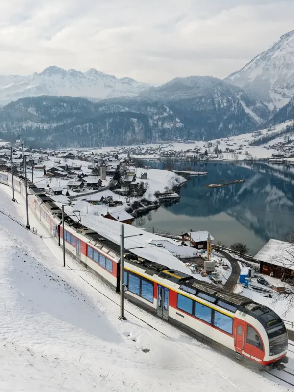 On a cold snowy winter day, a Lucerne-Interlaken Express travels thru Lungern village in Switzerland