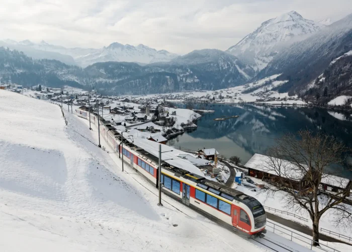 On a cold snowy winter day, a Lucerne-Interlaken Express travels thru Lungern village in Switzerland