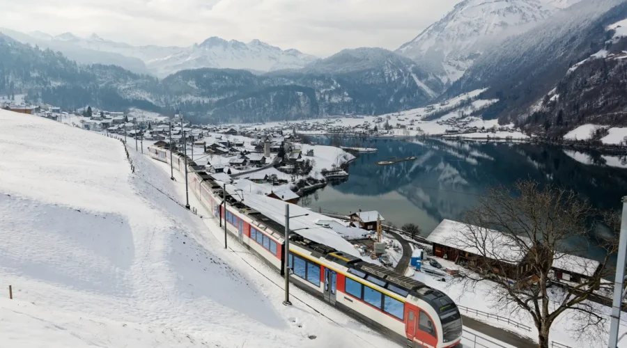 On a cold snowy winter day, a Lucerne-Interlaken Express travels thru Lungern village in Switzerland